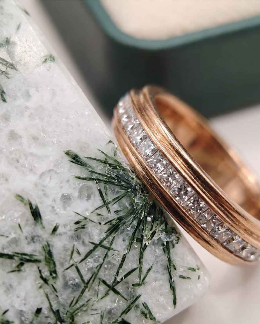 Close-up rose gold pavé band ring with sparkling clear stones along the band