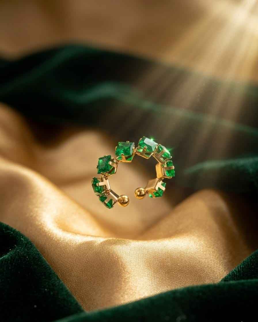Open band ring with green emerald-cut stones in gold-tone bezel settings