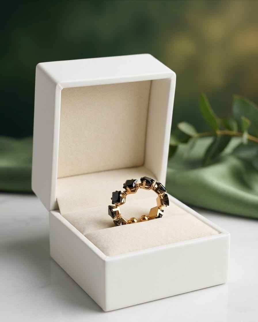 Gemstone ring in gold-tone with dark square stones, shown in a white gift box