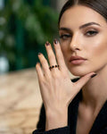 Gemstone ring with black square stones in gold-tone prong setting on model hand