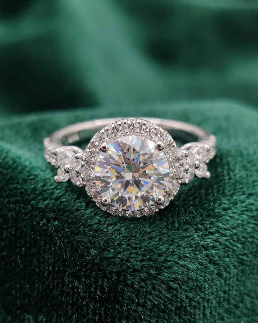 Oval halo diamond ring with large center stone on dark green velvet