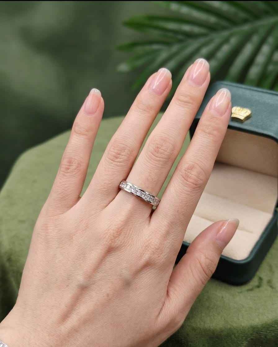 Silver eternity band ring with small clear stones on a hand