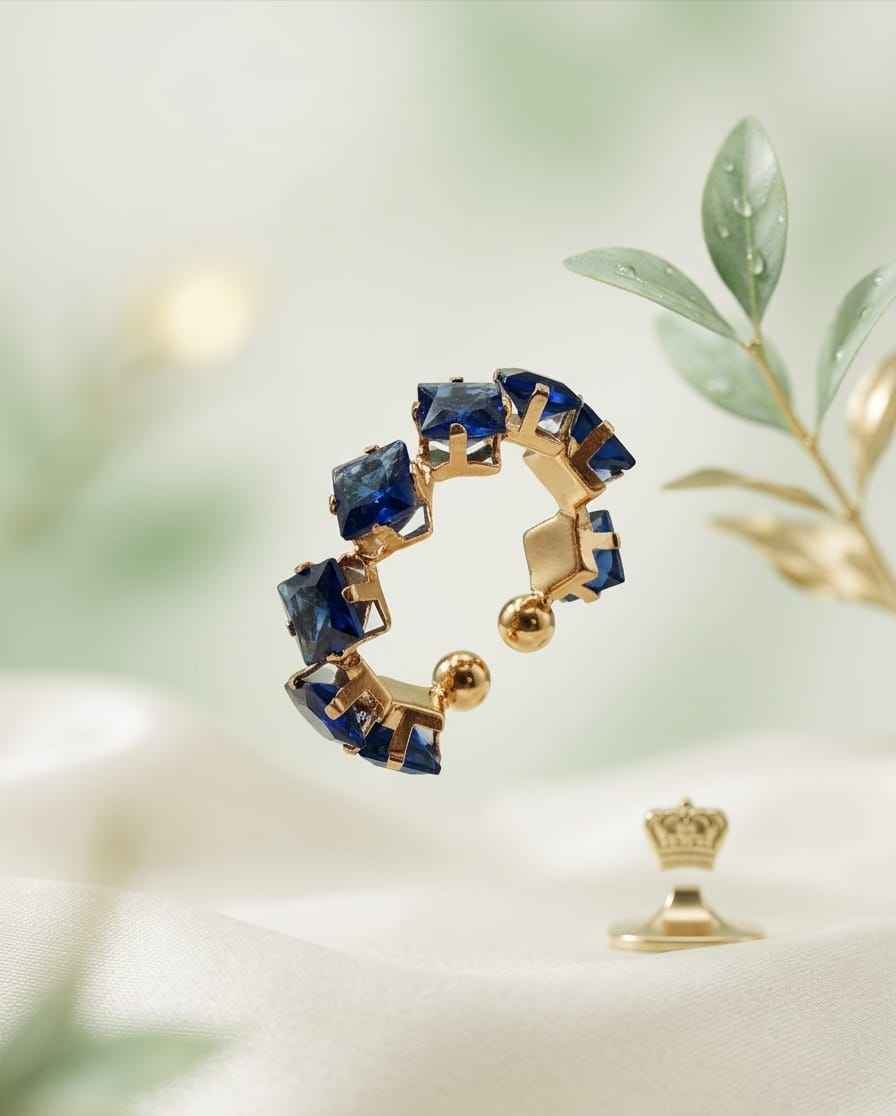 Gold-tone open ring with dark blue square stones in an oval band