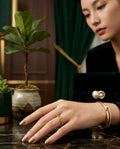 Gold chain-weave ring with openwork links on a hand
