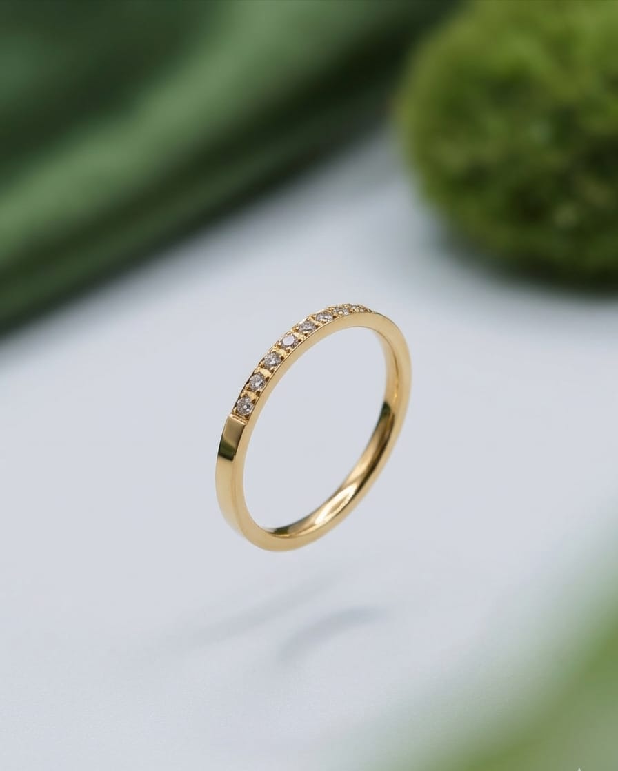 Gold pavé ring with small stones, angled view on a light surface