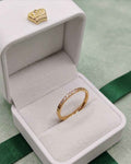Gold pavé dainty ring with small clear stones in a white ring box