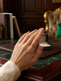 Open loop ring on hand, gold-tone open lattice band with rounded links.