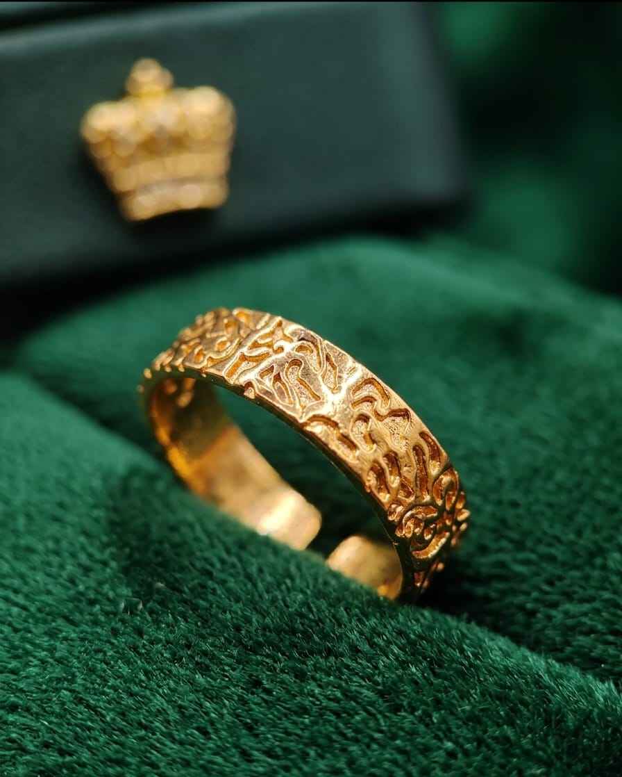 Gold-tone engraved band ring with raised pattern, wide open cuff design