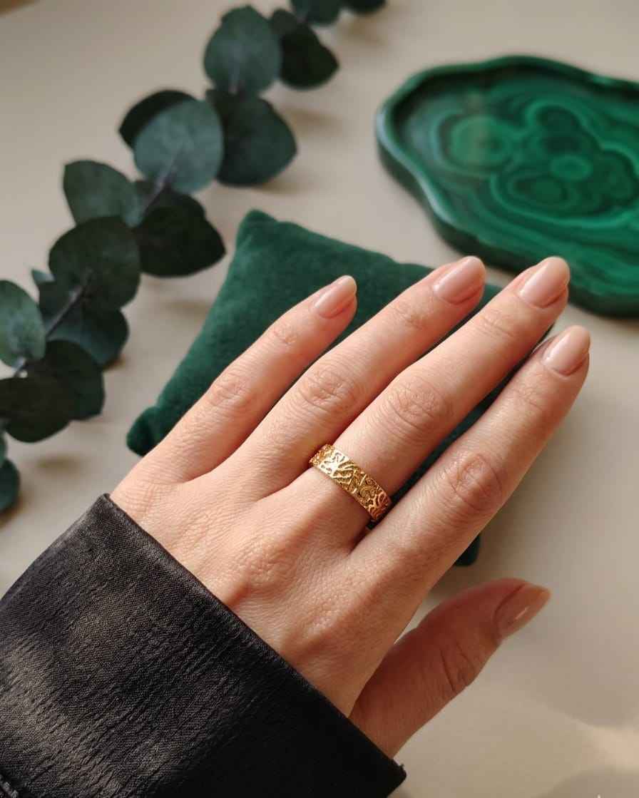 Gold-tone engraved band ring on hand, slim finger fit