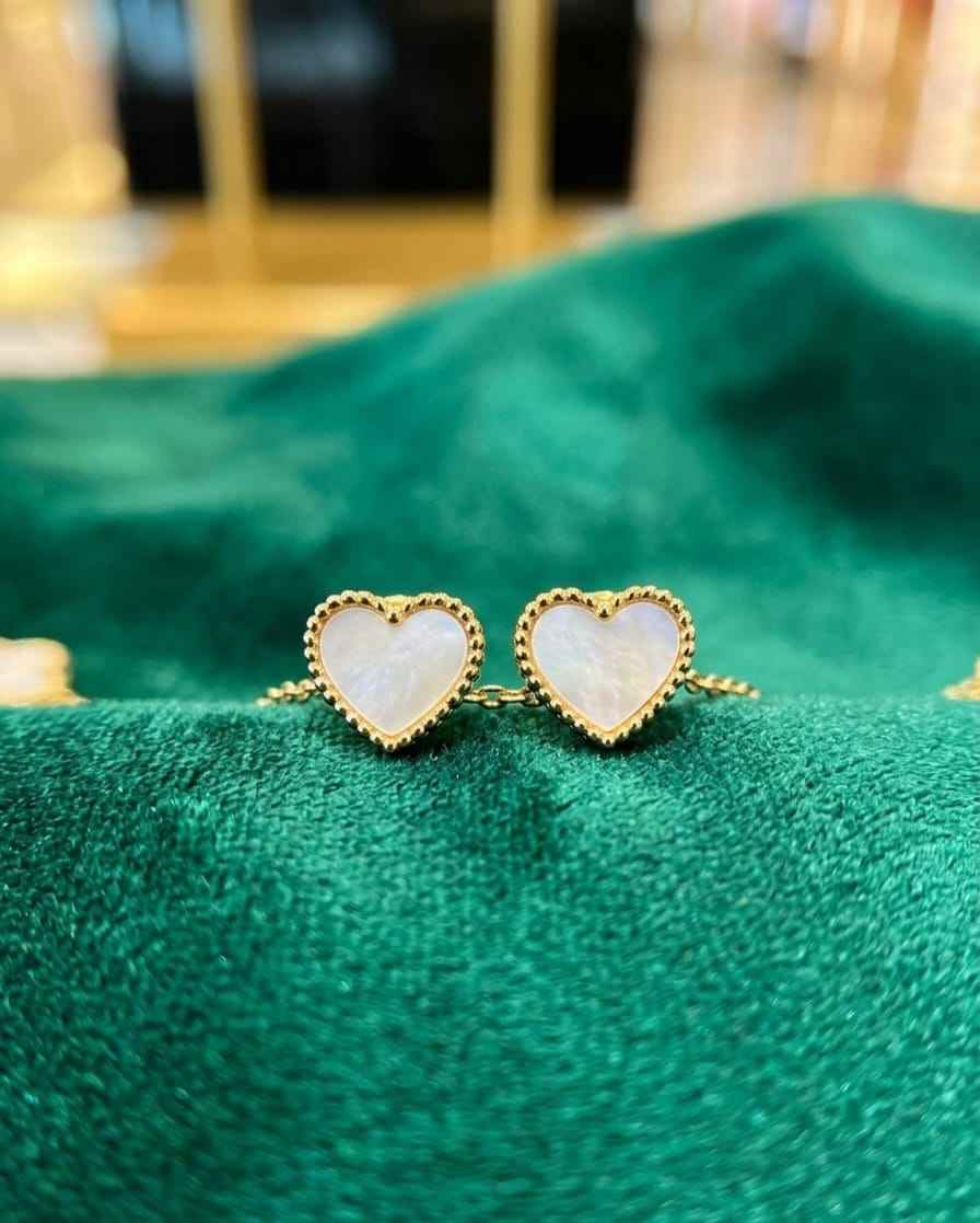 Gold heart stud earrings with white enamel centers