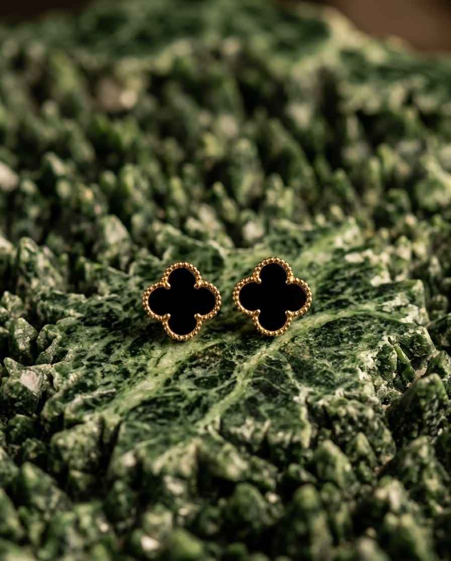 Gold-tone clover stud earrings with black enamel centers