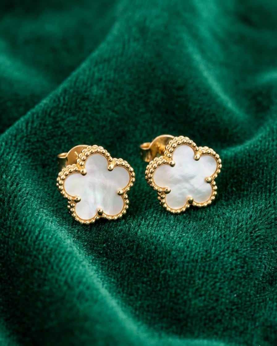 Gold clover charm stud earrings with white enamel detail