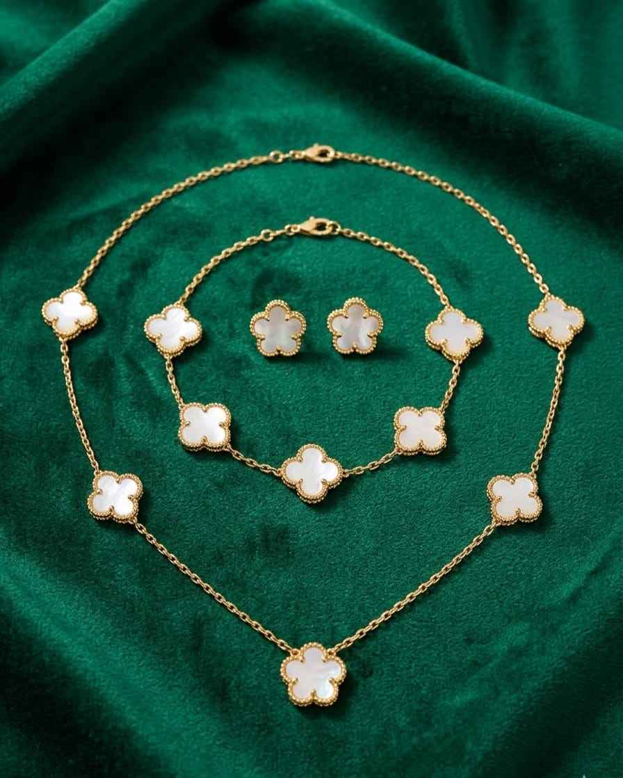 Gold clover charm necklace and bracelet with white enamel flower charms