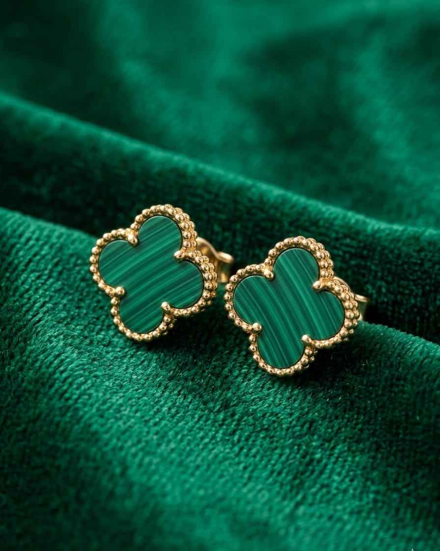 Gold clover stud earrings with green enamel accents