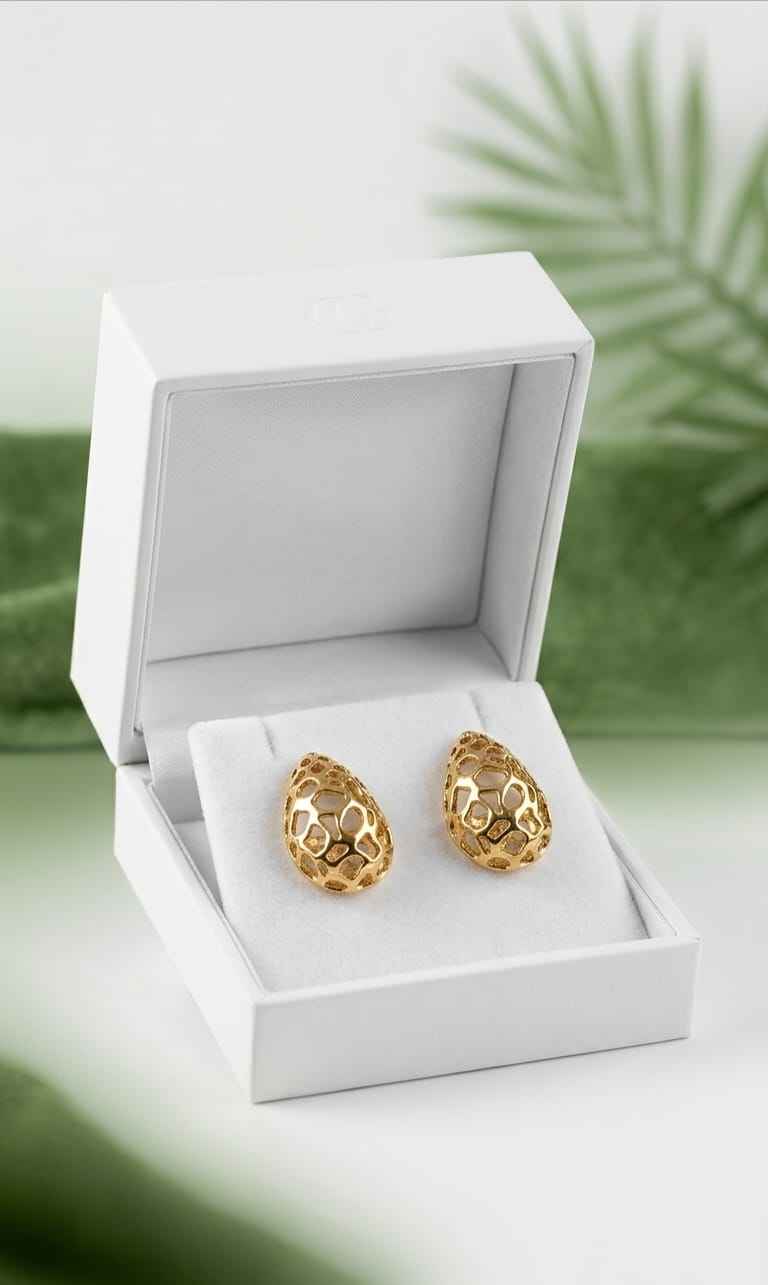 Gold filigree teardrop stud earrings in open gift box, paired on white cushion