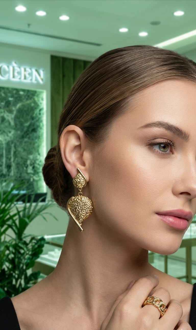 Gold-tone filigree heart drop earrings worn with dangling textured heart pendants and bar details.