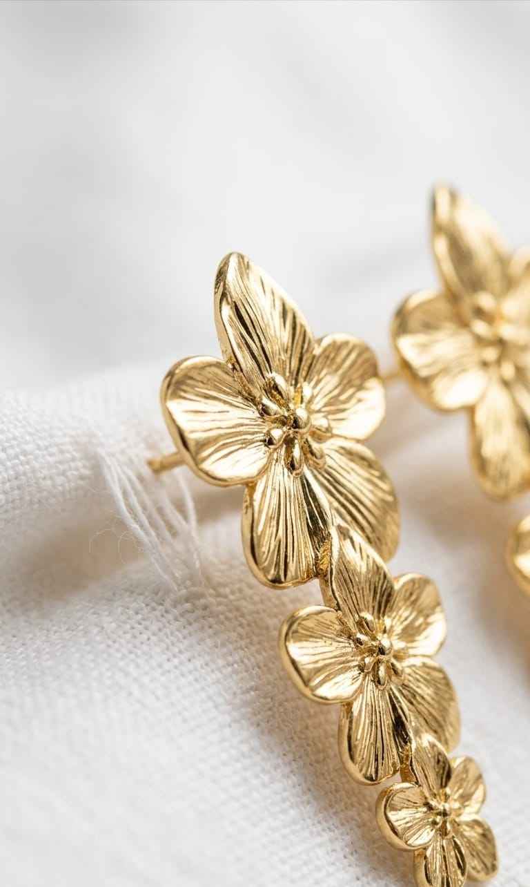Gold flower drop earrings with close-up layered blossoms and textured petals