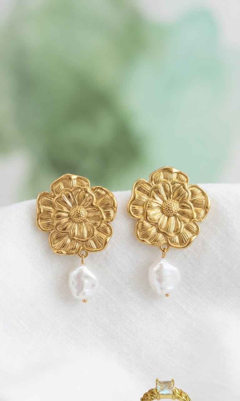 Gold floral earrings with white pearl dangles, pair shown together