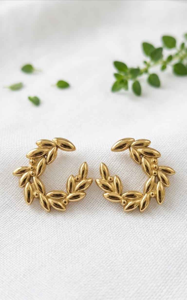 Gold leaf wreath hoop earrings with clustered leaf links forming a circular frame